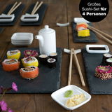 Großes Sushi-Set für vier Personen auf Schieferplatten, mit verschiedenen Sushi-Rollen, Sojasoße, Wasabi und Ingwer, aus der Vogelperspektive fotografiert.