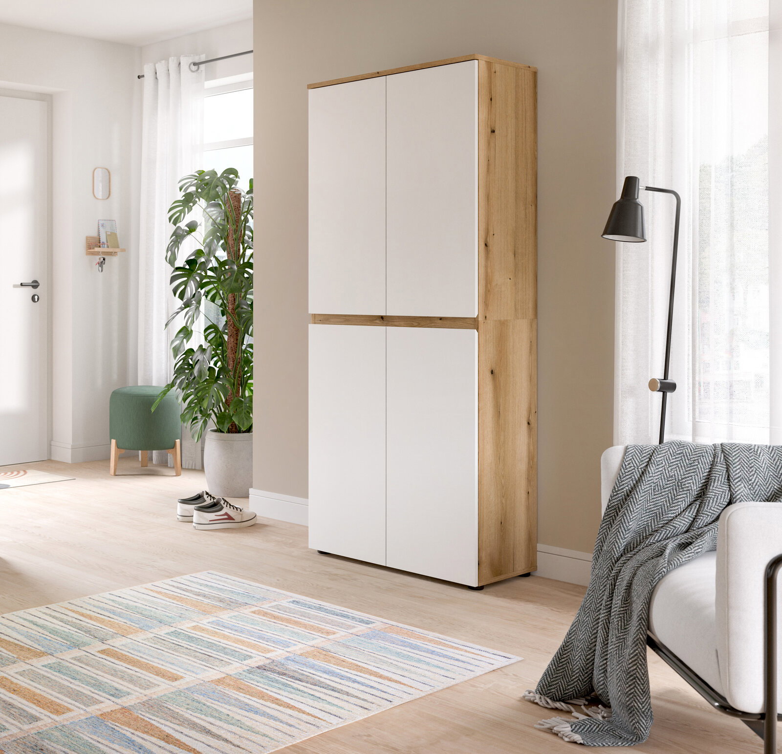 MID.YOU Universalschrank SCARPA Hoher, moderner Schrank mit vier weißen Türen und Korpus in heller Holzoptik, freistehend im hellen Wohnraum; Perspektive: frontale Ansicht mit leichter rechter Seitenansicht.