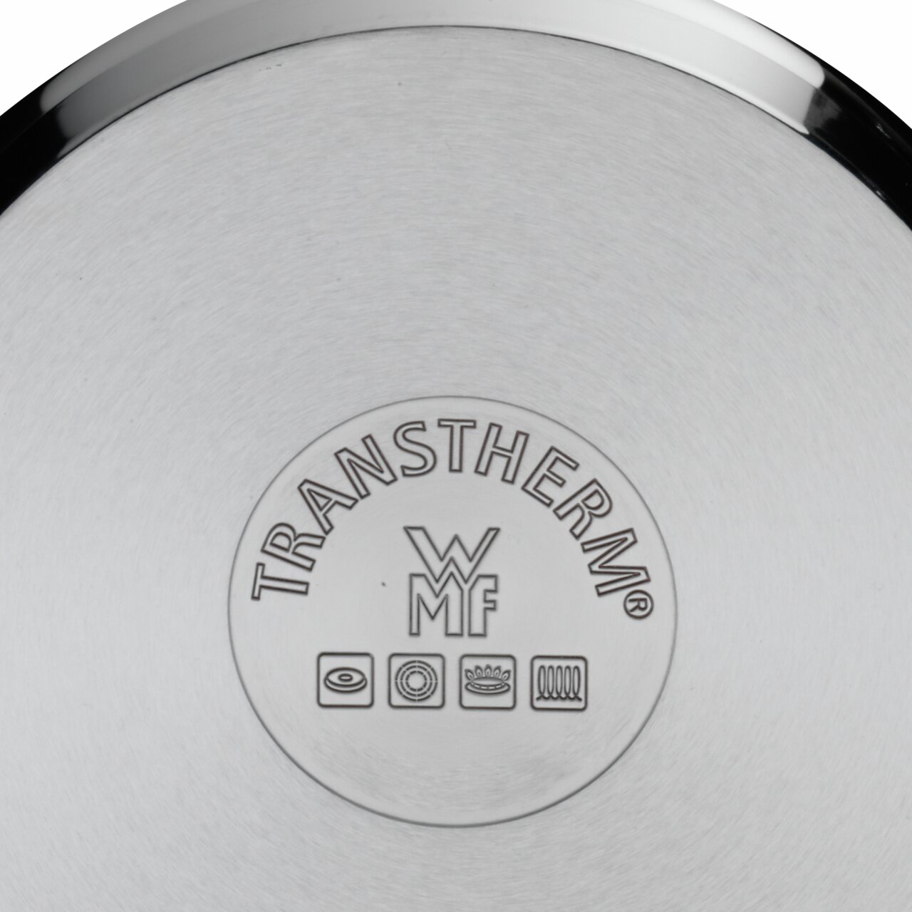 Een blik op de bodem van een pan met het WMF TransTherm-logo en symbolen voor verschillende soorten fornuizen.