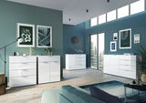 Modernes XL-Sideboard in einem stilvollen Wohnzimmer mit grüner Wandfarbe, dekorativen Bildern und großen Fenstern, seitliche Perspektive.