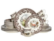 Porzellan-Geschirrset in Cremeweiß mit braunem Blumenrand und Tiermotiven (Fuchs, Hirsch, Vögel), bestehend aus Tellern, Schalen und Tassen, frontal in leicht schräger Perspektive auf weißem Hintergrund arrangiert
