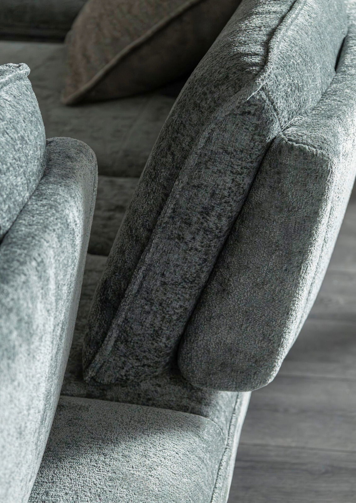 Nahaufnahme eines grauen Longchairs mit weicher Polsterung, seitliche Perspektive