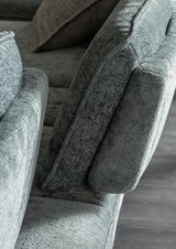 Nahaufnahme eines grauen Longchairs mit weicher Polsterung, seitliche Perspektive