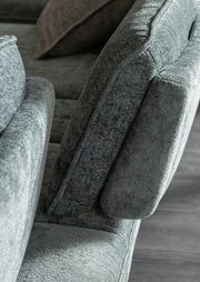 Nahaufnahme eines grauen Longchairs mit weicher Polsterung, seitliche Perspektive