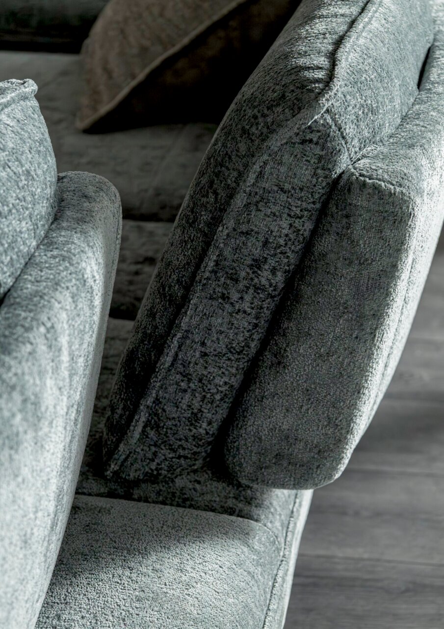Nahaufnahme eines grauen Longchairs mit weicher Polsterung, seitliche Perspektive