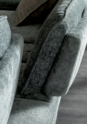 Nahaufnahme eines grauen Longchairs mit weicher Polsterung, seitliche Perspektive