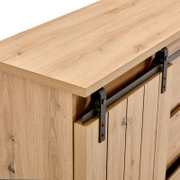 Detailweergave van een houten dressoir met schuifdeur en metalen beslag, gezien van bovenaf.