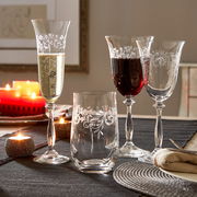 Sektkelch 190ml Romance mit elegantem Muster, gefüllt mit Sekt, auf einem festlich gedeckten Tisch mit Kerzenlicht, seitliche Perspektive