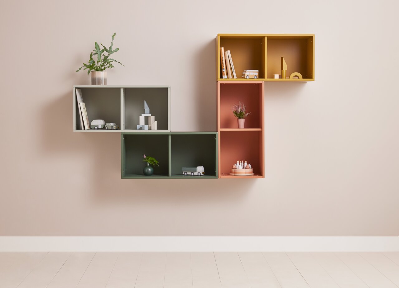 Wandregal ROOMIE von Flexa in verschiedenen Farben, frontal fotografiert, mit Dekorationen wie Pflanzen und Büchern.