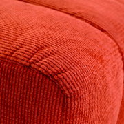 Nahaufnahme eines roten, strukturierten Hockers aus Stoff, perspektivisch von der Seite aufgenommen.