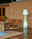 New Garden LED-Outdoor Stehlampe LOLA LED Outdoor Stehlampe Lola 165, beleuchtet, auf einer Terrasse neben zwei Holzliegen und einer Ziegelwand, seitliche Perspektive