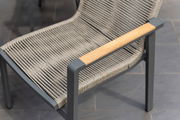 Moderner Stapelsessel mit grauem Metallrahmen und geflochtener Sitzfläche, seitliche Perspektive