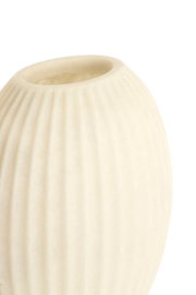 Detailansicht einer cremeweißen Vase mit sanft gerippter, fein strukturierter Oberfläche, aus leicht erhöhter Perspektive vor weißem Hintergrund