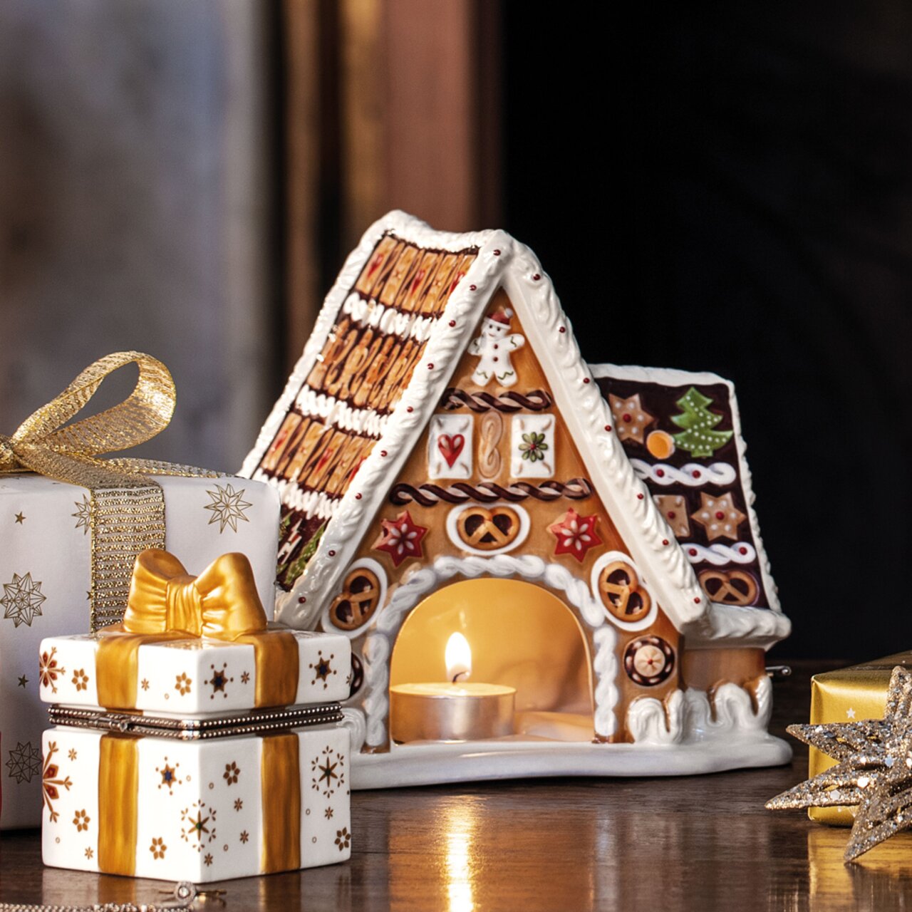 Lebkuchenhaus mit Spieluhr, dekoriert mit bunten Details und einem Teelicht im Inneren, seitliche Perspektive.