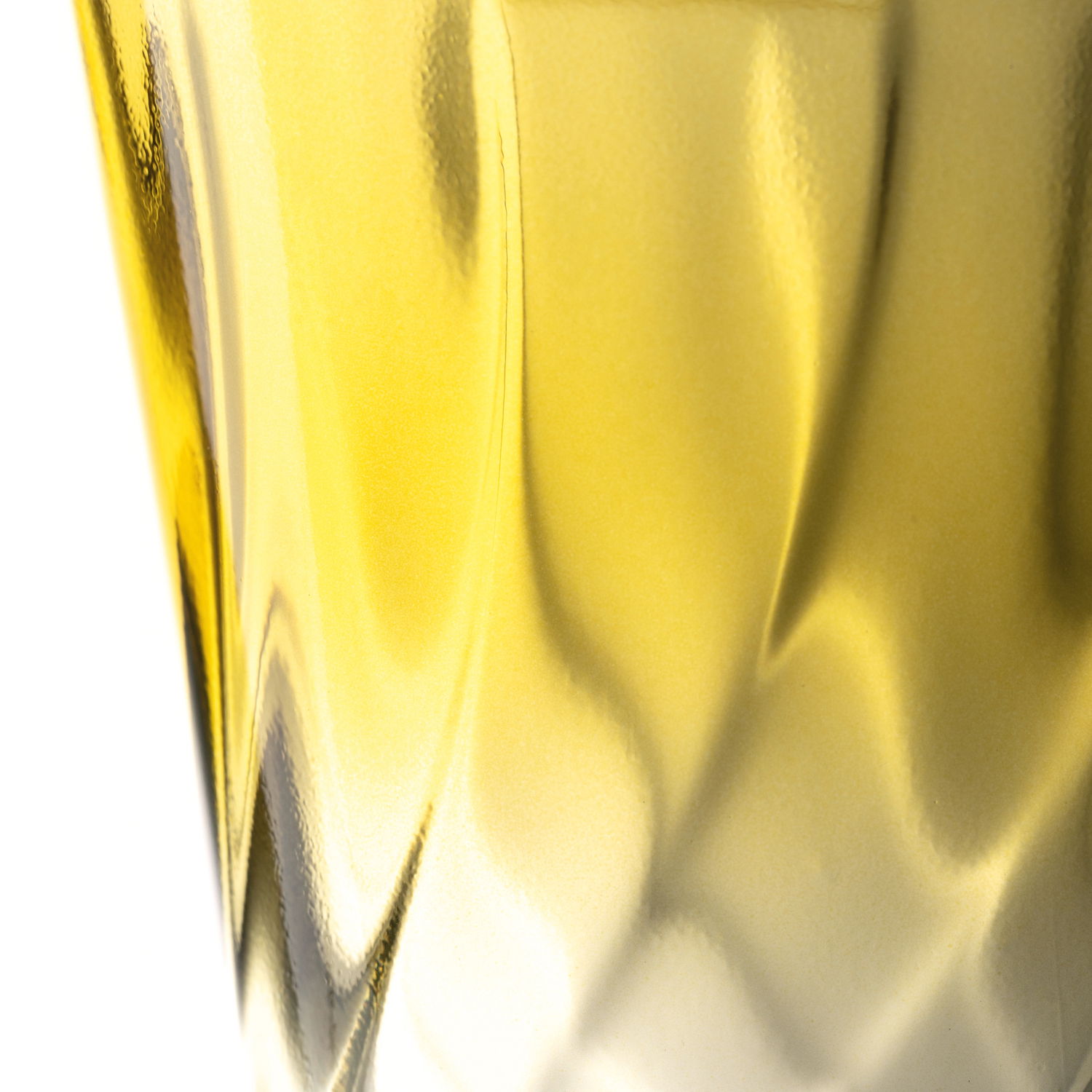 Nahaufnahme eines gelben Trinkglases mit gedrehtem Design, seitliche Perspektive