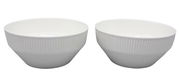 Zwei weiße Schüsseln mit geriffelter Oberfläche, seitliche Perspektive