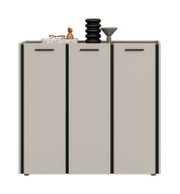 Modernes Sideboard/Kommode in Hellgrau mit drei Türen und schwarzen Griffleisten, freigestellt auf weißem Hintergrund; Frontansicht von leicht schräg oben, mit Deko (Brille, Holzfigur, schwarze Vase, graue Schale) auf der Oberplatte.