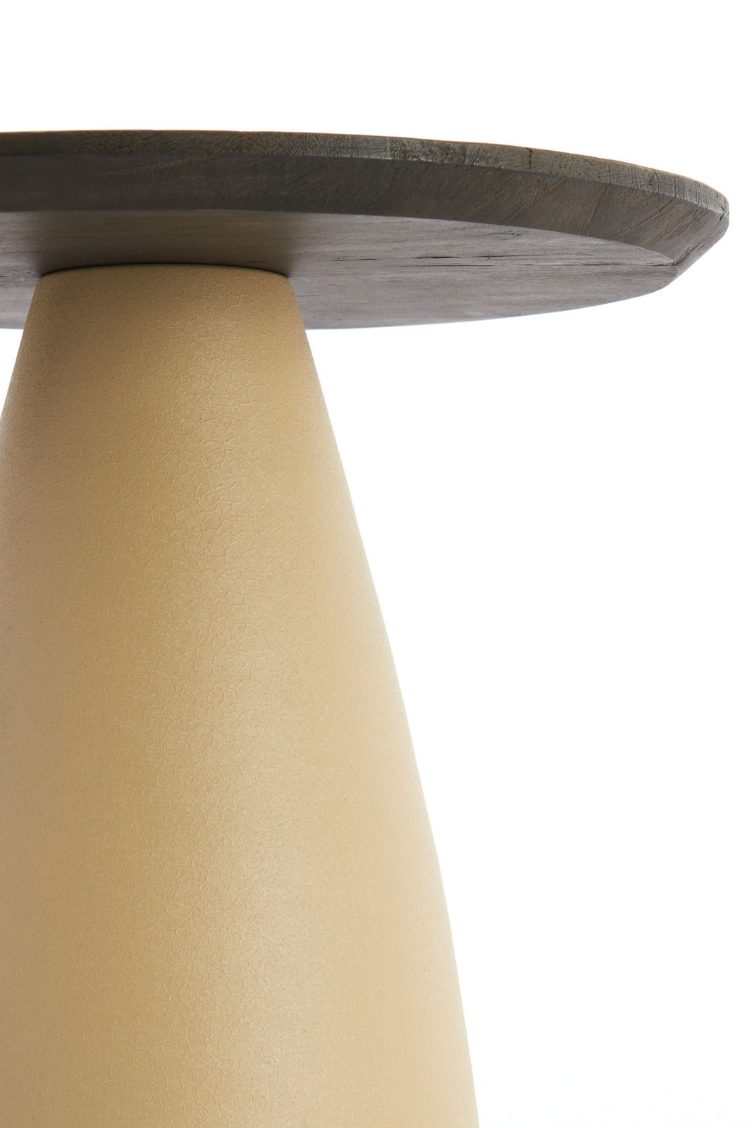 Nahaufnahme eines Beistelltisches mit konischer, beiger Basis und runder, dunkler Tischplatte, seitliche Perspektive.