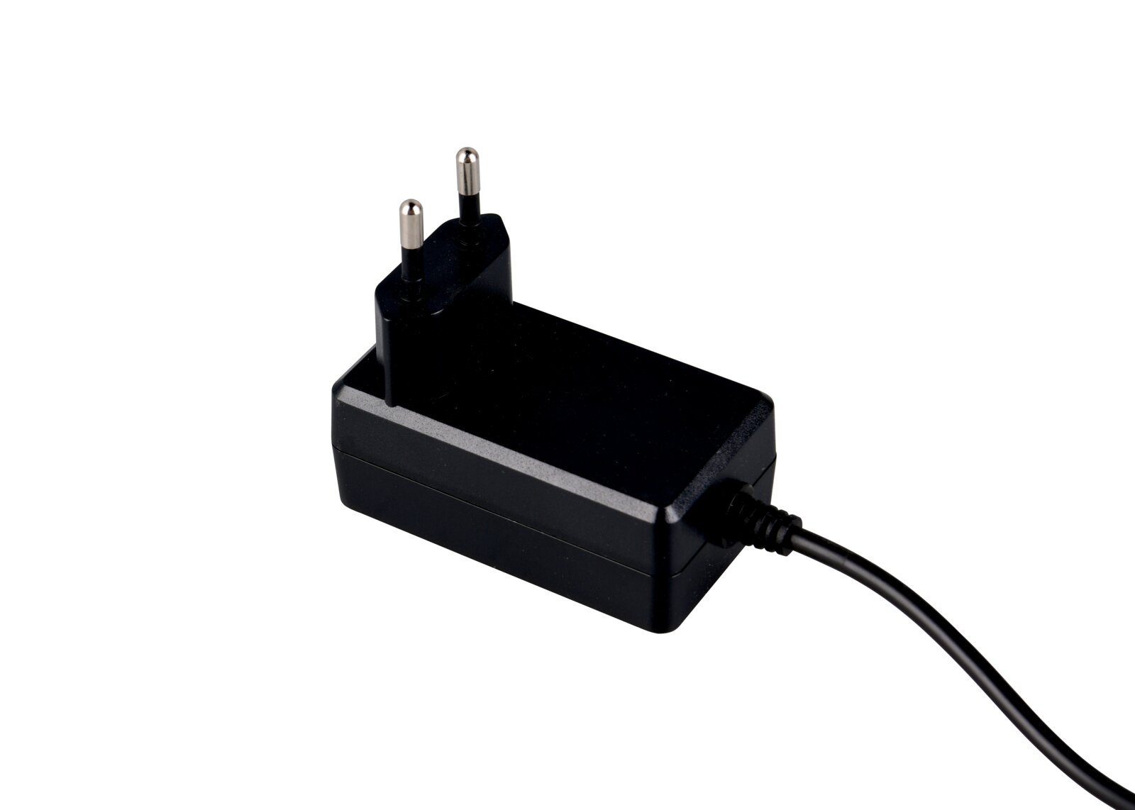 Schwarzes Netzteil mit EU-Stecker und fest angeschlossenem Kabel, freigestellt auf weißem Hintergrund, in schräger Seitenansicht von oben
