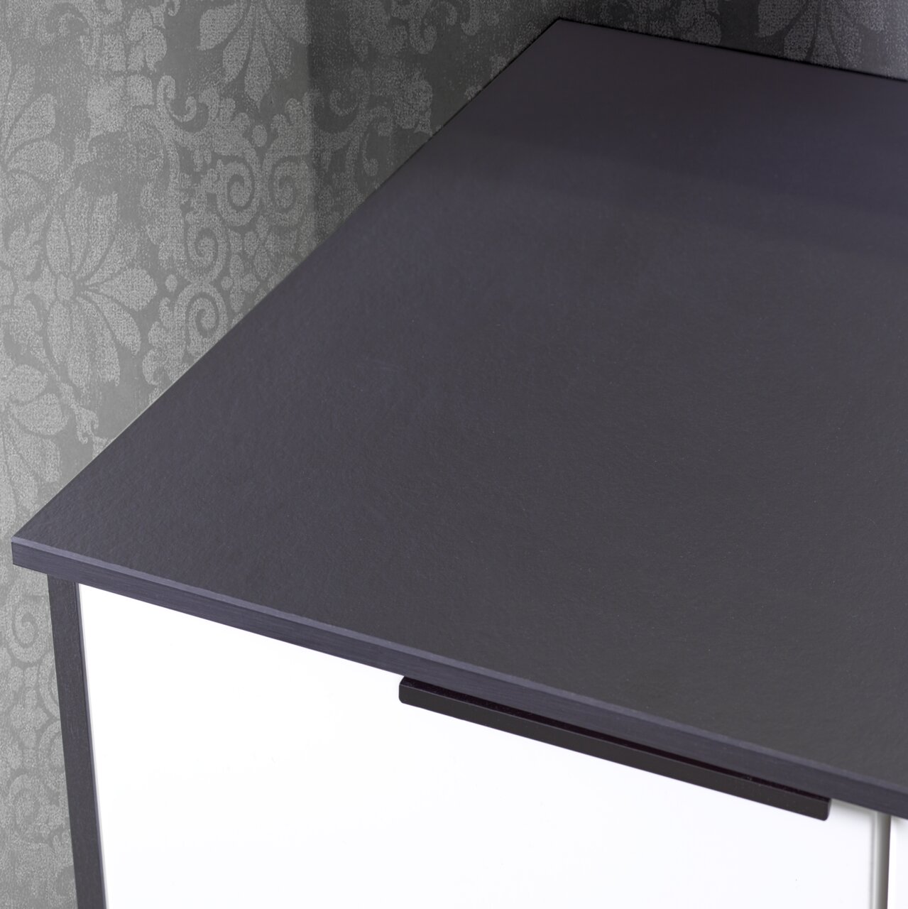 Nahaufnahme eines Waschtisch-Sets mit dunkler Oberfläche und modernem Design, von oben betrachtet.