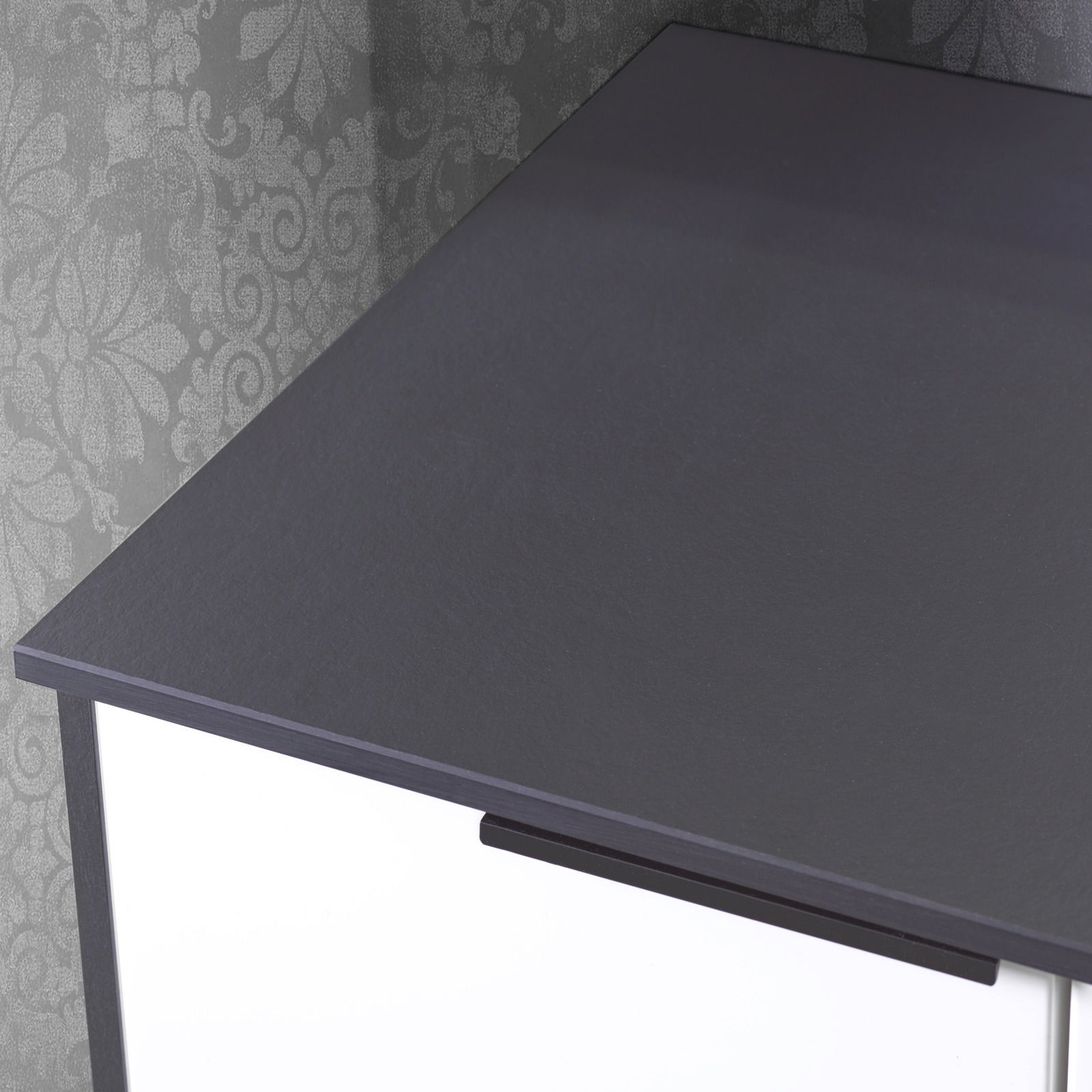 Nahaufnahme eines Waschtisch-Sets mit dunkler Oberfläche und modernem Design, von oben betrachtet.