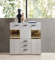 Modernes Highboard in Weiß mit schwarzen Griffen, dekoriert mit Vasen und Büchern, frontal fotografiert.