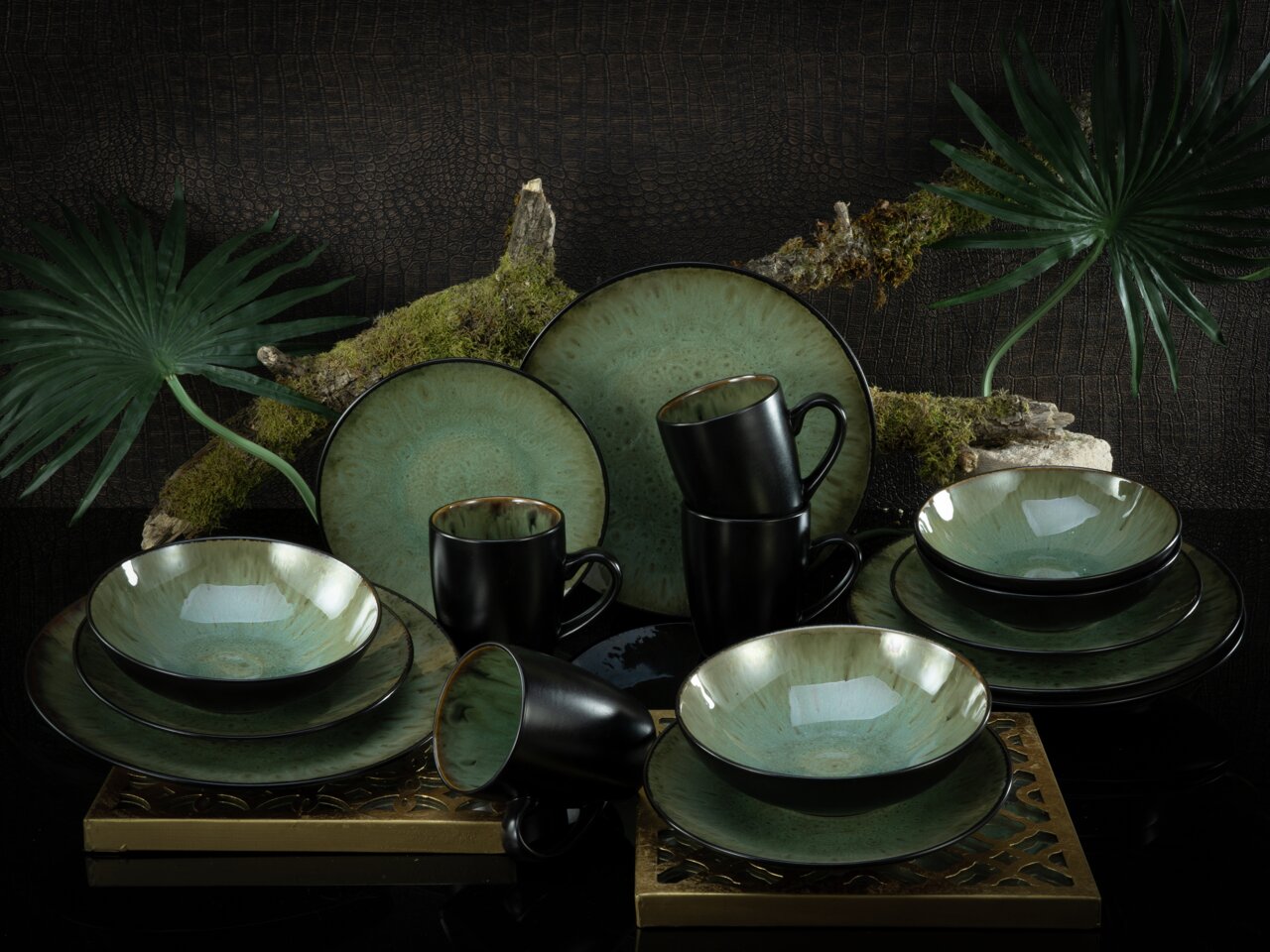 Elegantes Kombiservice Jawa 16-tlg. in grüner und schwarzer Keramik, präsentiert in einer stilvollen, natürlichen Umgebung mit Moos und Blättern, aus der Vorderansicht.