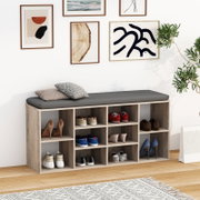 Schuhregal mit Sitzbank in heller Holzoptik und grauem Sitzpolster, mehrere offene Fächer mit Schuhen und Kissen, frontale Perspektive im Wohnraum.