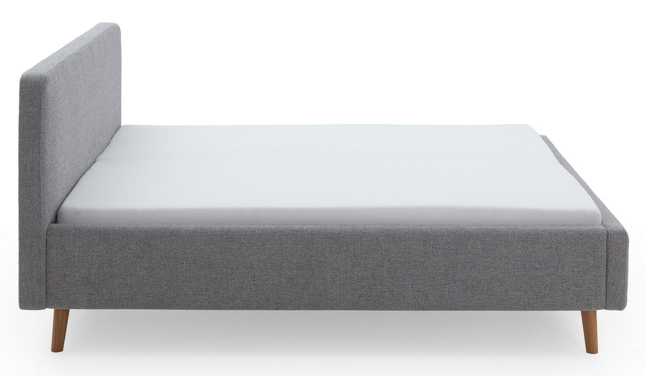 Seitliche Ansicht eines grauen Polsterbettgestells mit Holzfüßen und schlichtem Design.