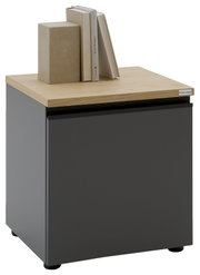Moderner Nachttisch/Beistellschrank mit mattschwarzer Front und heller Holzplatte, oben mit Büchern und Deko-Box, Produktansicht in leichter Schrägansicht von vorne rechts.