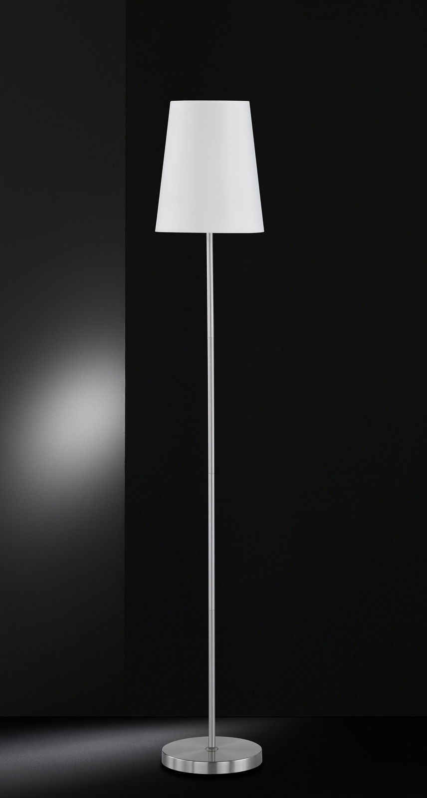 WOFI Leuchten Staande lamp FYNN Moderne Stehleuchte mit weißem Lampenschirm und silbernem Standfuß, frontal abgebildet vor schwarzem Hintergrund.