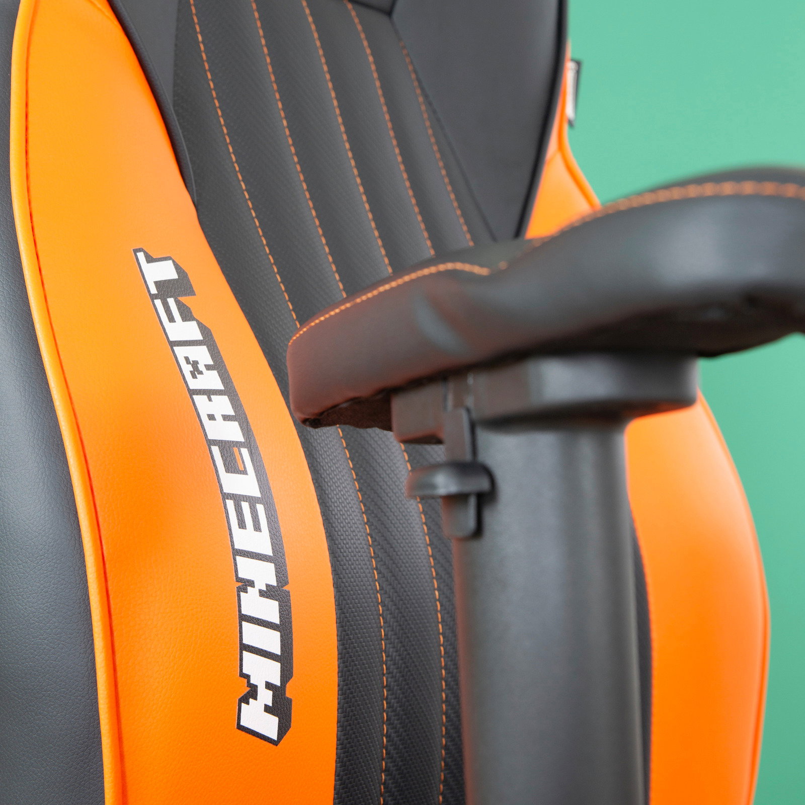 Nahaufnahme eines Gaming-Stuhls mit orangefarbenen und schwarzen Details, Minecraft-Logo auf der Rückenlehne, seitliche Perspektive