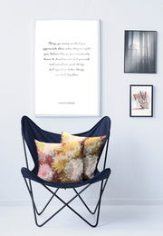 Zwei Kissenhüllen mit floralem Muster auf einem blauen Stuhl, seitliche Perspektive.