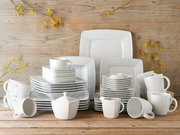 Kombiservice 50-tlg in moderner, quadratischer Form, bestehend aus Tellern, Tassen und Schalen, auf einem Holztisch arrangiert, frontal fotografiert.