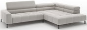 Lichtgrijze, gestoffeerde L-vormige hoekbank met chaise longue rechts, blokstiksel en zwarte metalen poten, getoond in schuin vooraanzicht op witte achtergrond.