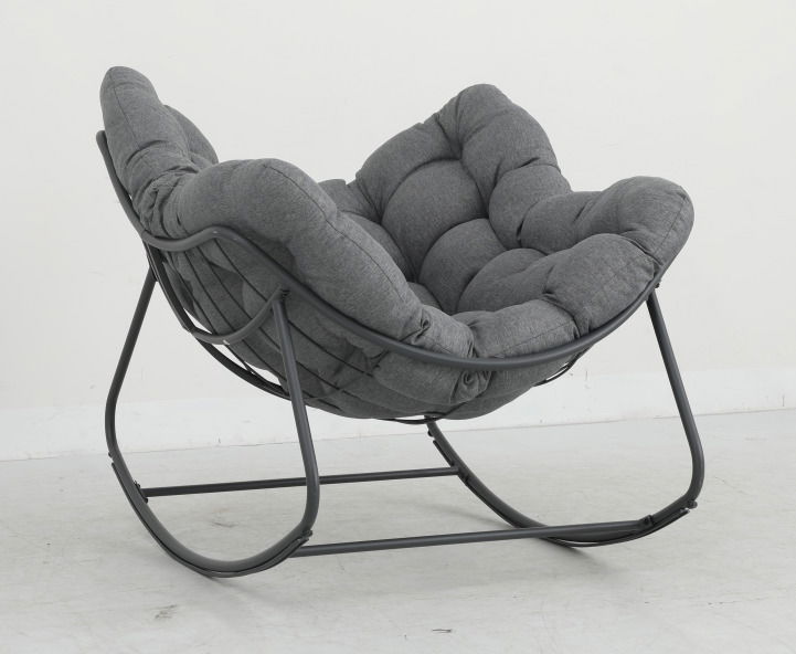 Grauer Schaukelsessel mit gepolstertem Sitz und Metallrahmen, seitliche Perspektive