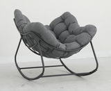 Grauer Schaukelsessel mit gepolstertem Sitz und Metallrahmen, seitliche Perspektive