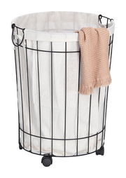 Wäschesammler mit Rollen aus schwarzem Metallgestell und weißem Stoffeinsatz, mit einem beigen Handtuch an der Seite, aus frontaler Perspektive.