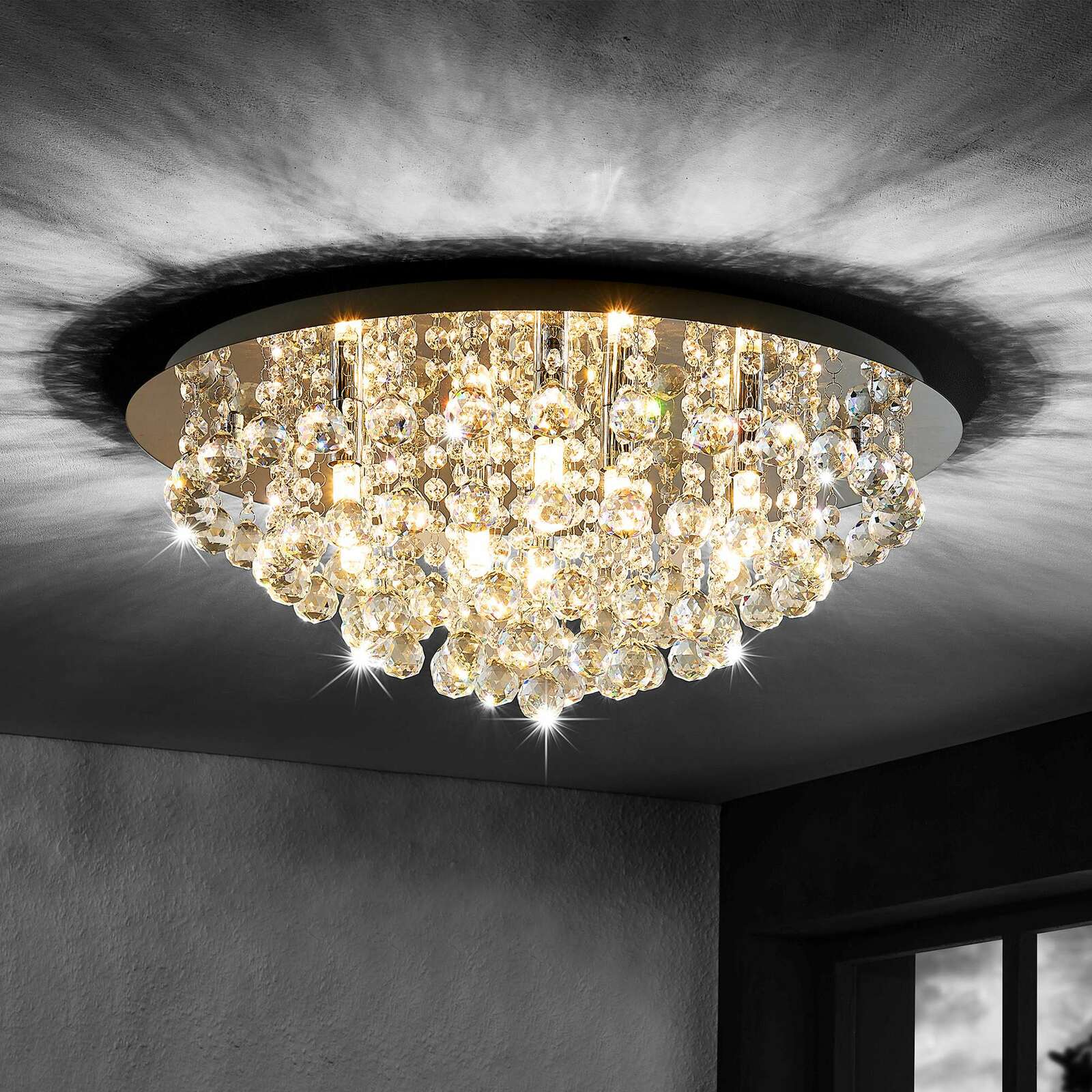 Novel Deckenleuchte Elegante Deckenleuchte mit funkelnden Kristallen, von unten betrachtet, die ein warmes Licht an die Decke wirft.