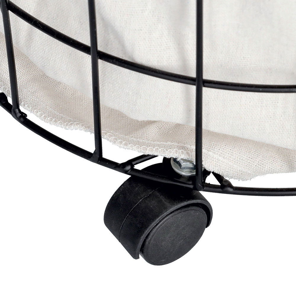 Nahaufnahme eines Wäschesammlers mit Rollen, schwarzes Metallgestell und beiger Stoffeinsatz, Perspektive von unten seitlich