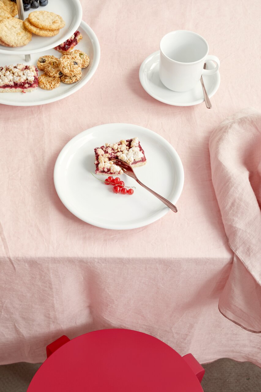 Thomas Frühstücksteller TREND WEISS Frühstücksteller aus weißem Porzellan mit einem Stück Kuchen und roten Johannisbeeren, von oben fotografiert.