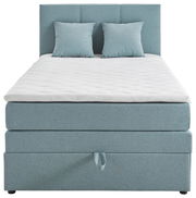 Boxspringbett in hellblauem Stoff mit zwei passenden Kissen, frontal fotografiert