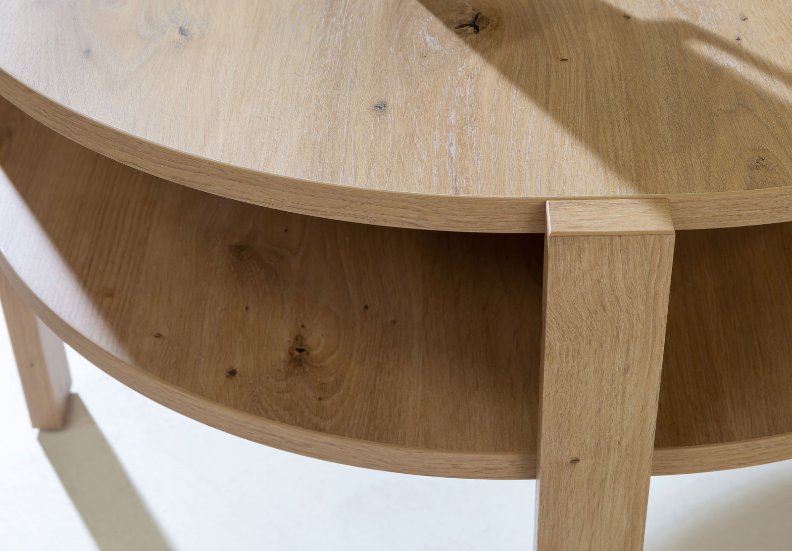 Nahaufnahme eines runden Couchtisches aus Holz mit zwei Ebenen, von oben betrachtet.