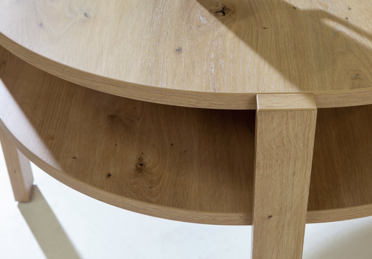 Nahaufnahme eines runden Couchtisches aus Holz mit zwei Ebenen, von oben betrachtet.
