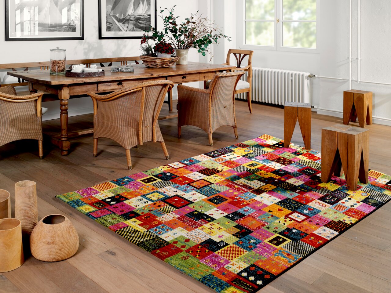 Bunter Designer Teppich mit Patchwork-Muster in einem stilvoll eingerichteten Esszimmer, aus der Perspektive von schräg oben fotografiert.