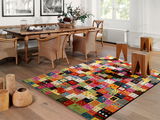 Bunter Designer Teppich mit Patchwork-Muster in einem stilvoll eingerichteten Esszimmer, aus der Perspektive von schräg oben fotografiert.