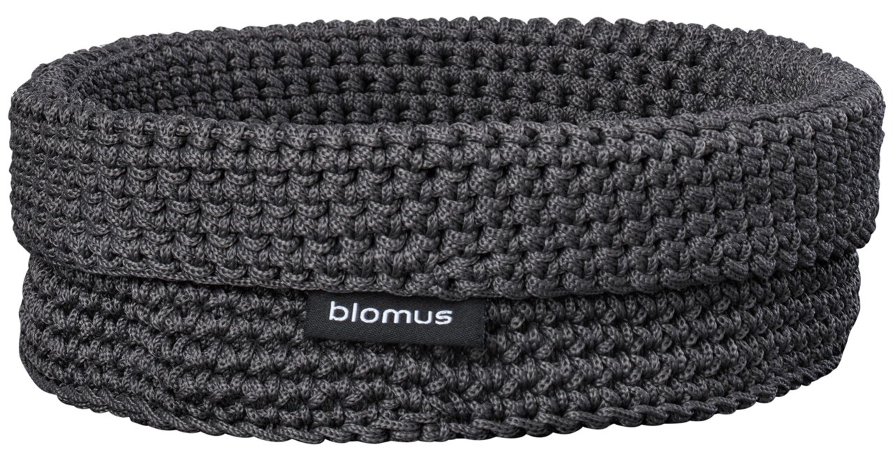 Dunkelgrauer, gehäkelter Aufbewahrungskorb von blomus mit Stofflabel, freigestellt auf weißem Hintergrund, Frontansicht leicht von oben