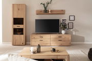 Wohnzimmeransicht mit moderner Wandkombination aus hellem Holz, bestehend aus einem hohen Schrank, einem TV-Schrank und einem Wandregal, frontal betrachtet.