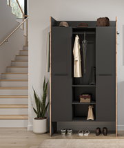 Moderner Garderobenschrank in Anthrazit mit Holzrahmen, geöffnet mit Mantel, Schirm und Ablagen, frontale Ansicht im Flur neben Treppe und Zimmerpflanze.