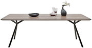 Moderner Esstisch mit Holzplatte und schwarzen Metallbeinen, seitliche Perspektive, dekoriert mit Vase, Weinglas und Schale.